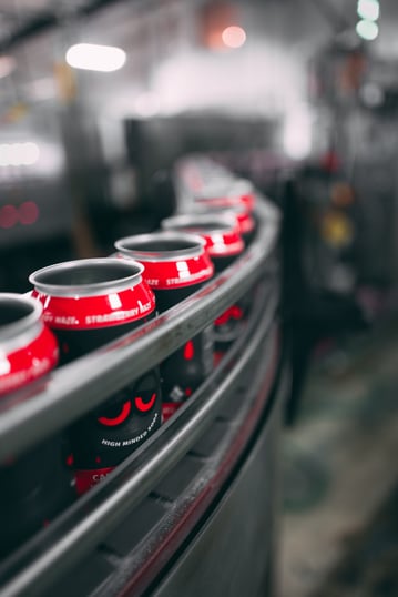 Soda cans moving through a factory