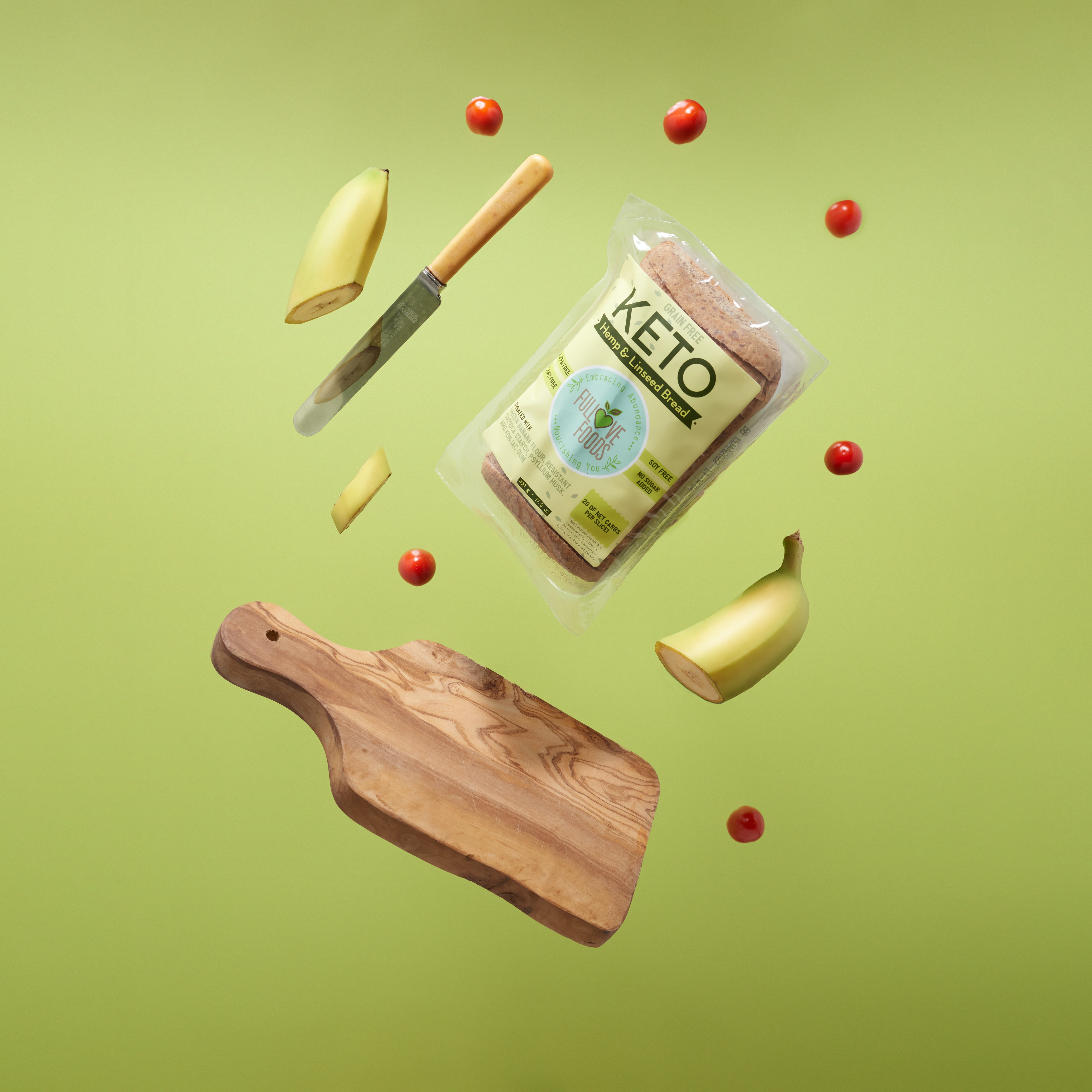 An image of a chopping board, knife, half-cut banana, and keto bread brand