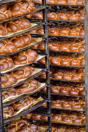 Two racks of fresh knotted bread straight from the bakery