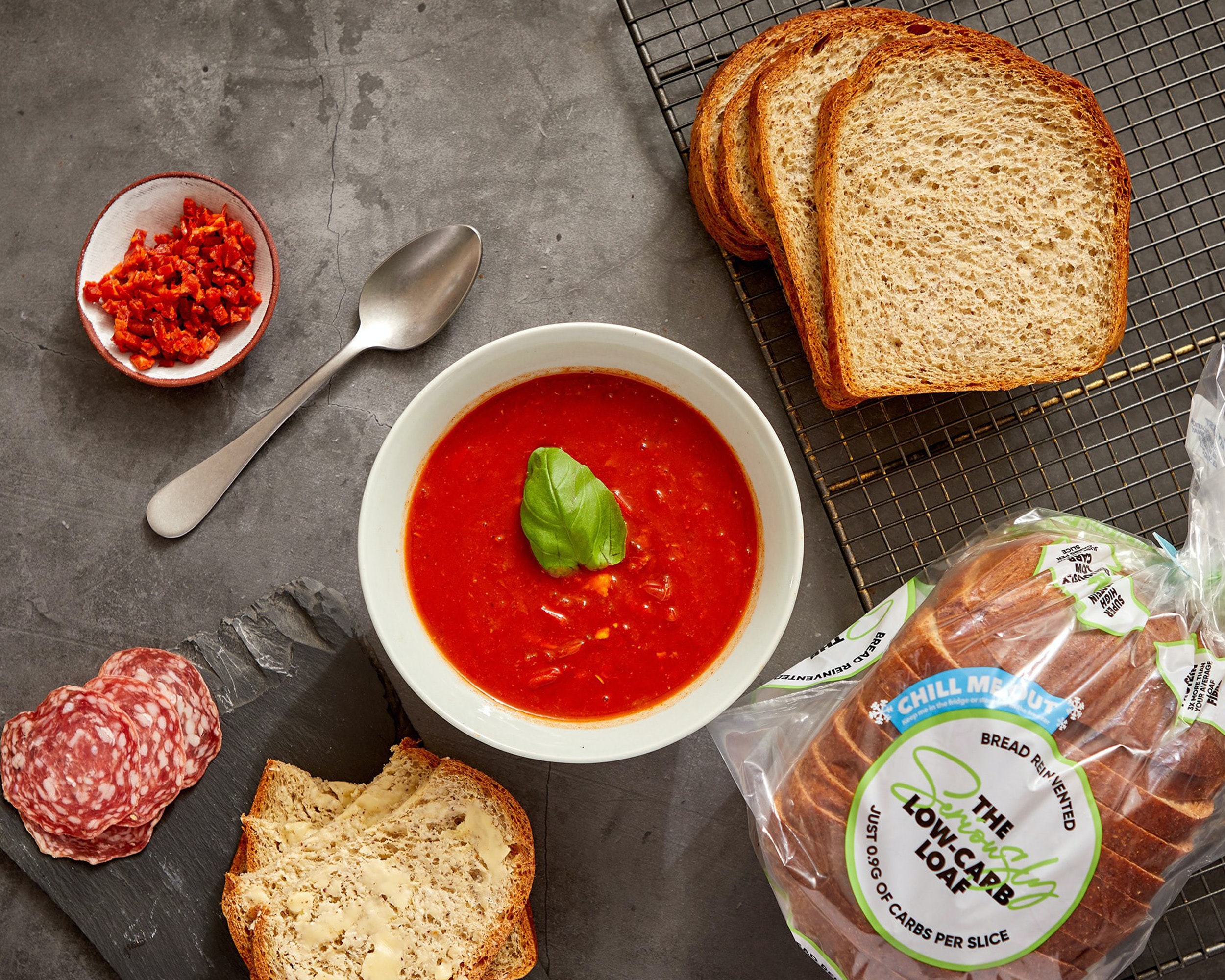 A bowl of tomato soup with slices of low-carb bread