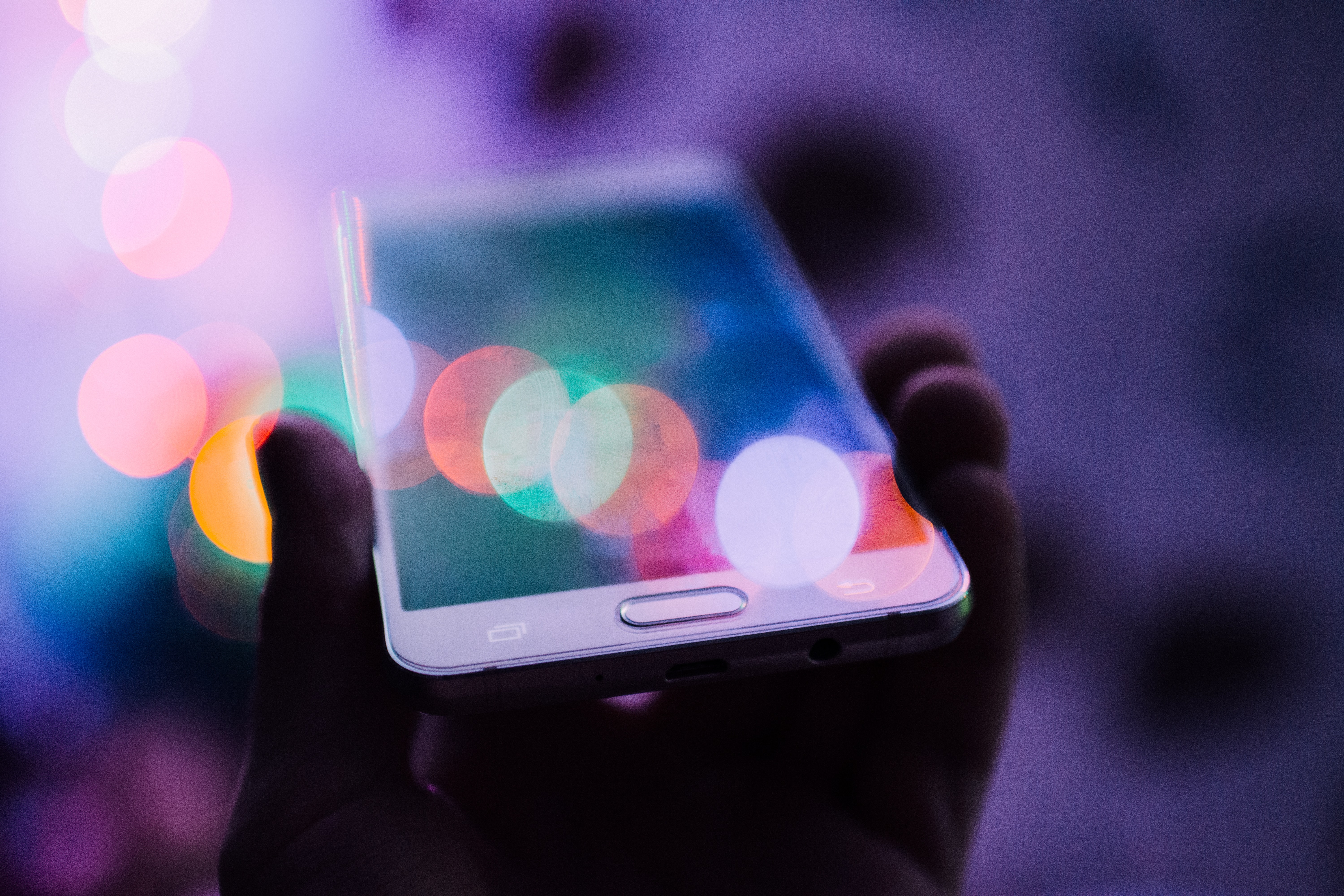 A low-lit photo of someone holding a cell phone