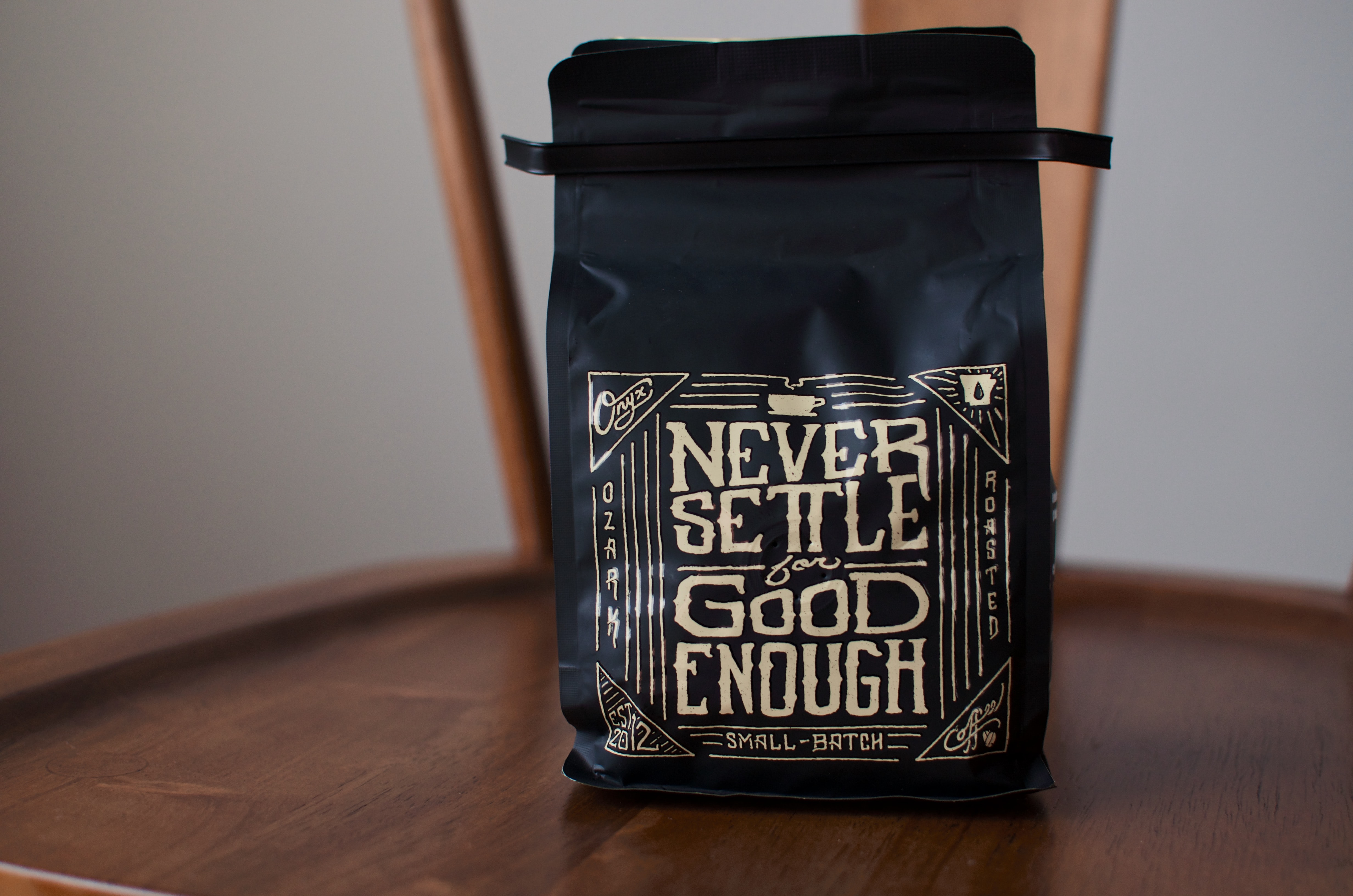 A fresh coffee package with the words 'Never settle for good enough' on the packaging