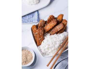 Cooked tempeh served in a bowl of white rice