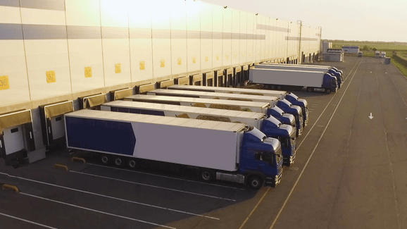 Row of delivery trucks backed up to a loading dock