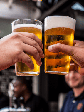 Two glasses of beer toasting