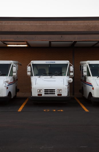 Three delivery trucks parked up in a lot