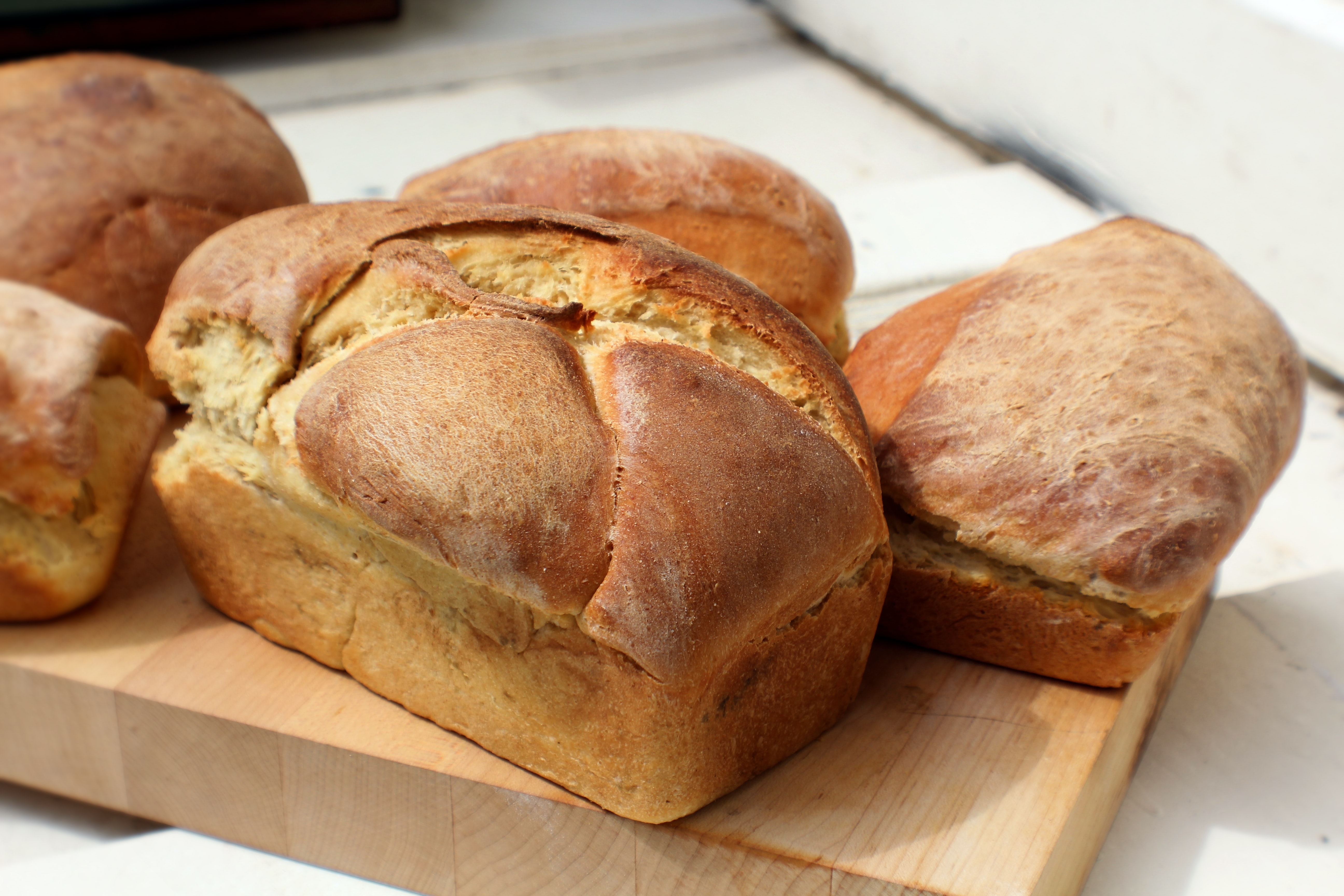 Fresh loaves of bread sat on a wooden board 