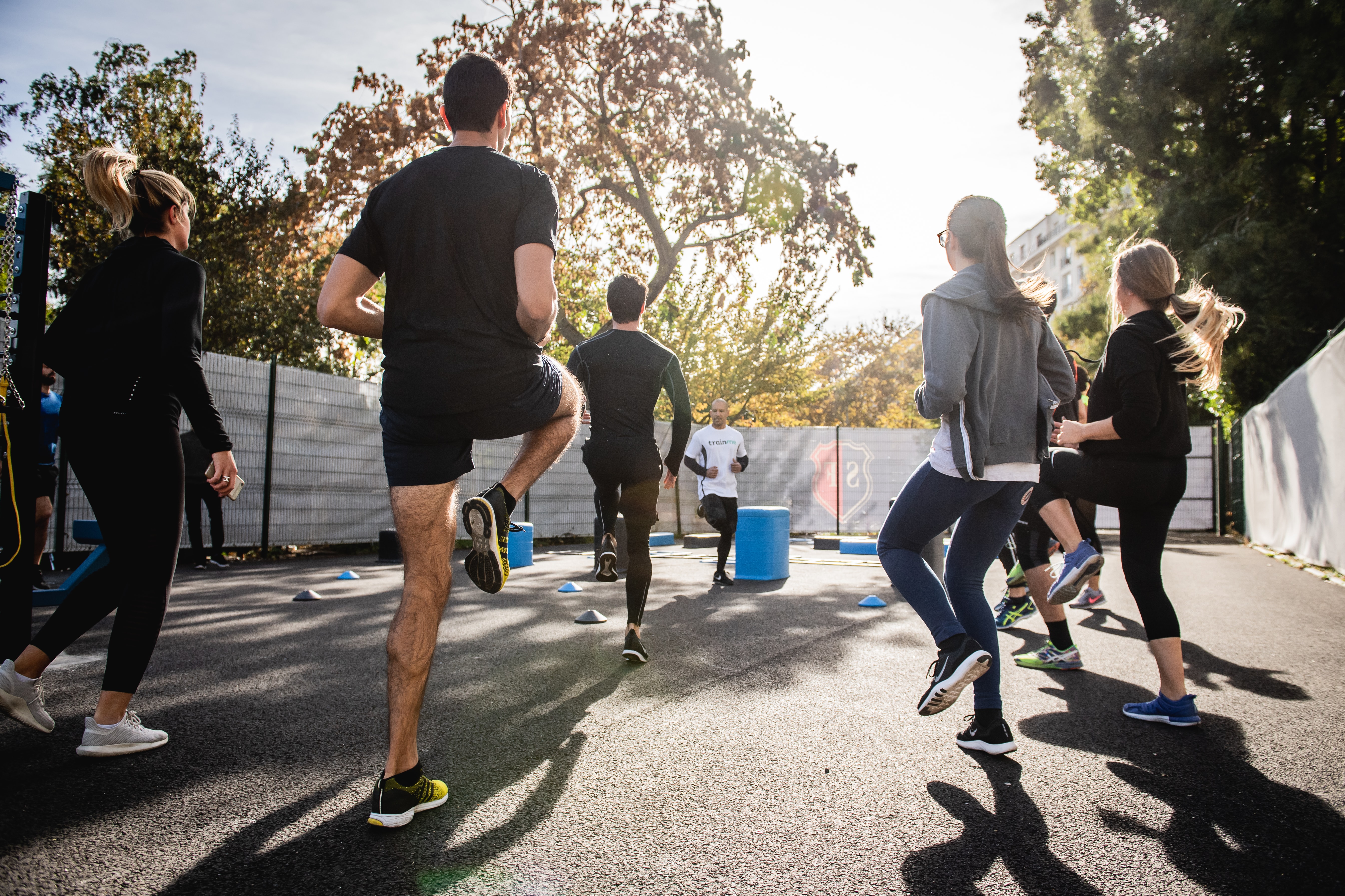 A group of people exercising outside on a sunny day