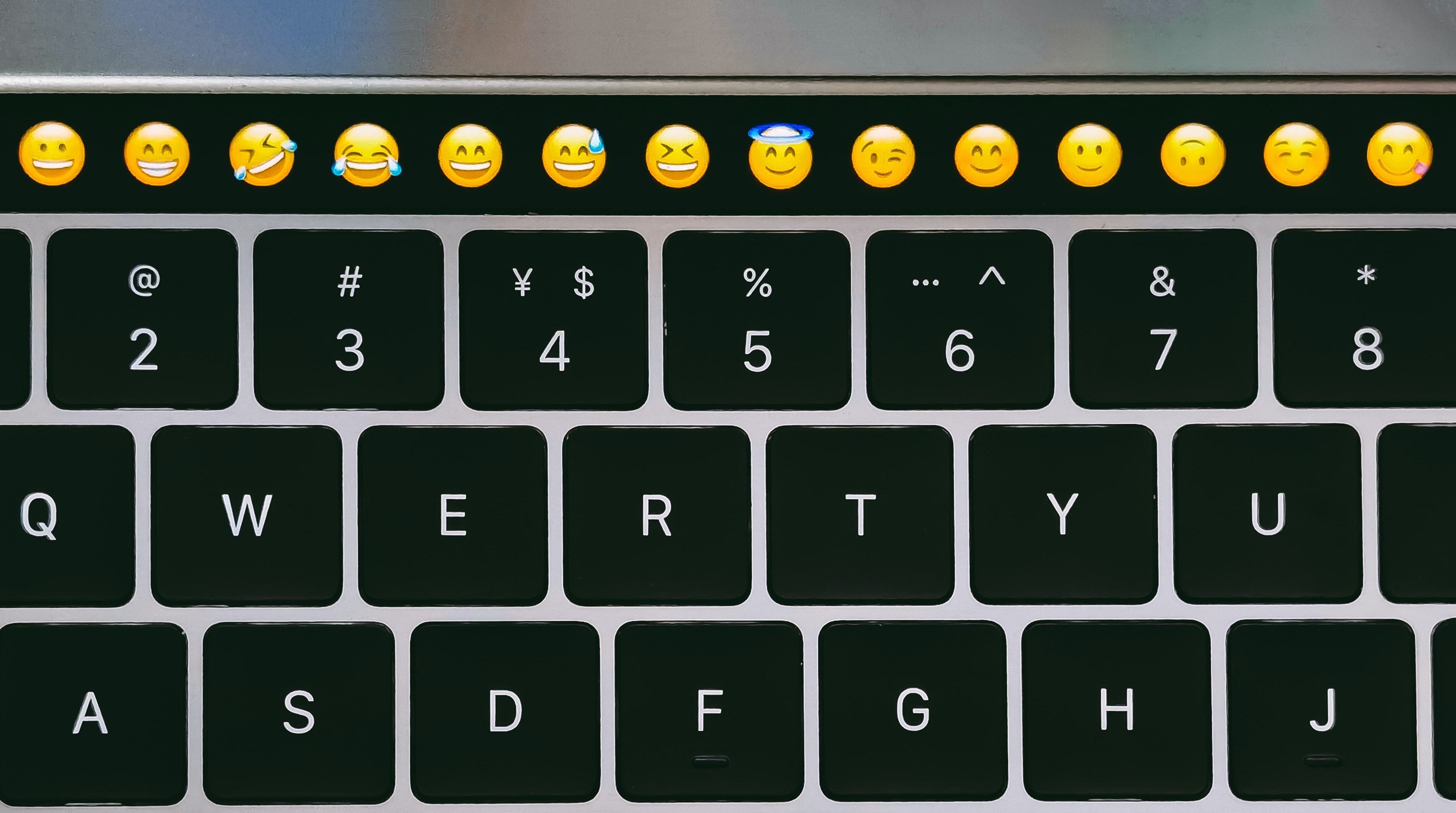 A close-up image of a computer keyboard with emoji buttons