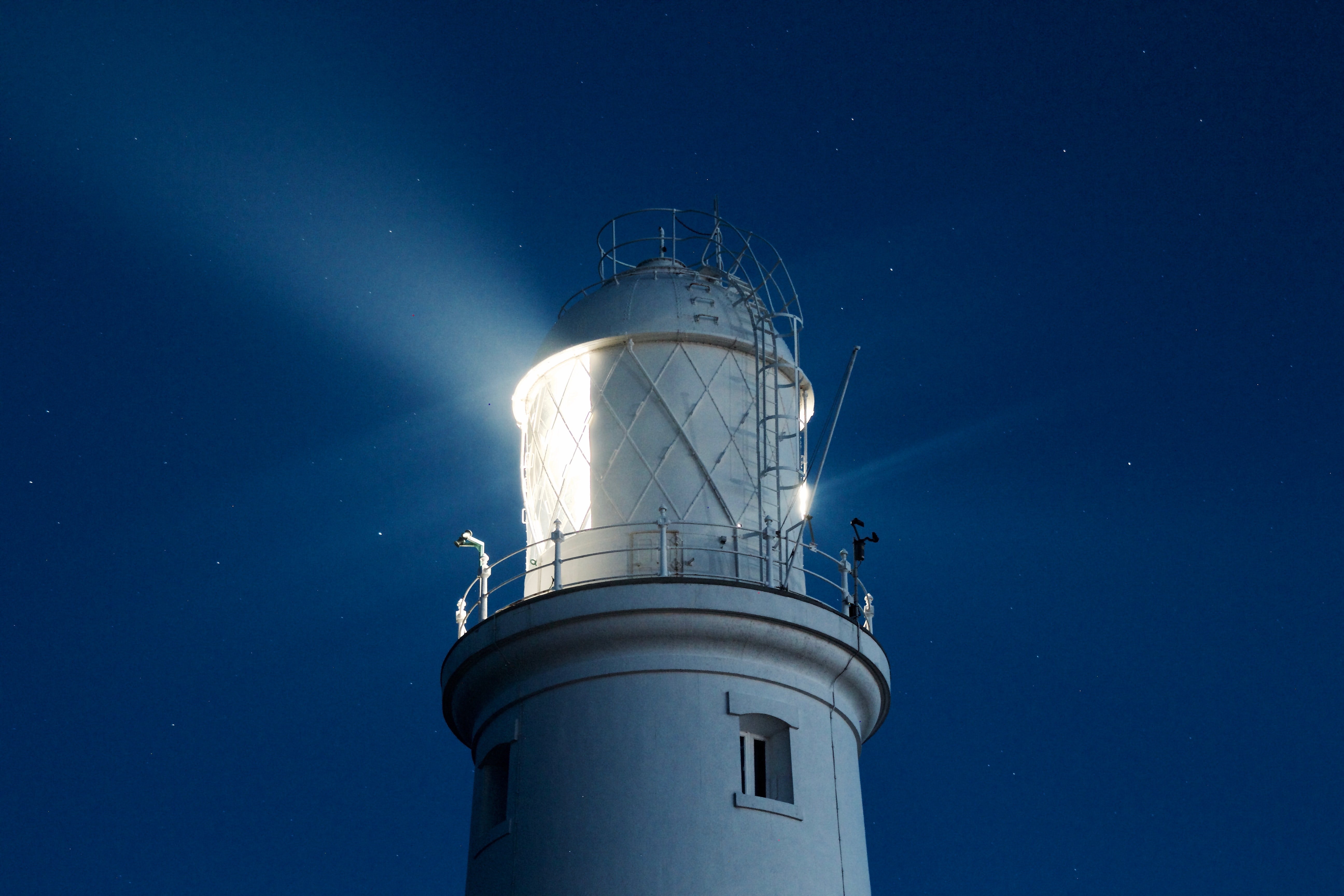 A lighthouse at night, sending out a signal