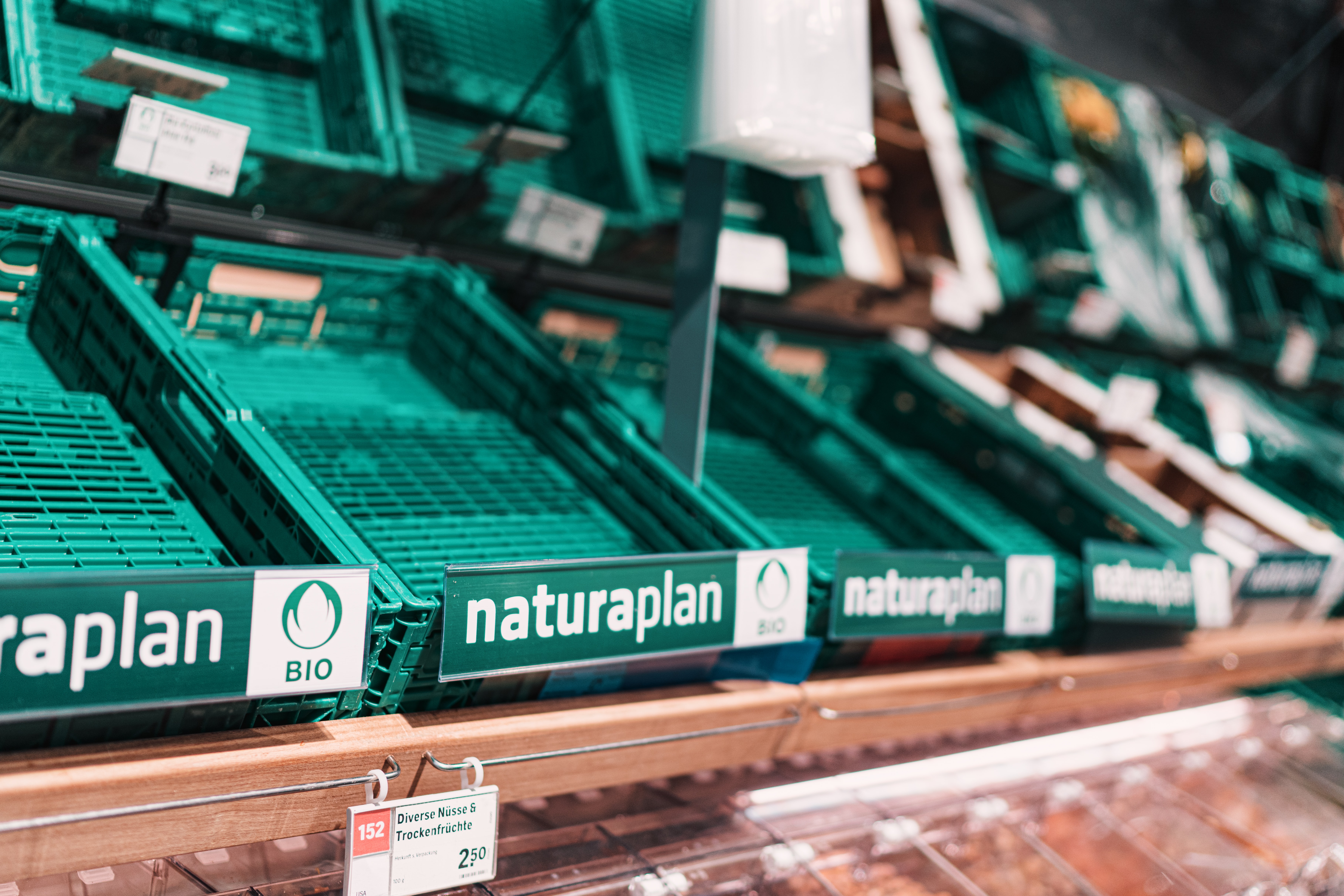 An empty set of grocery store vegetable shelves