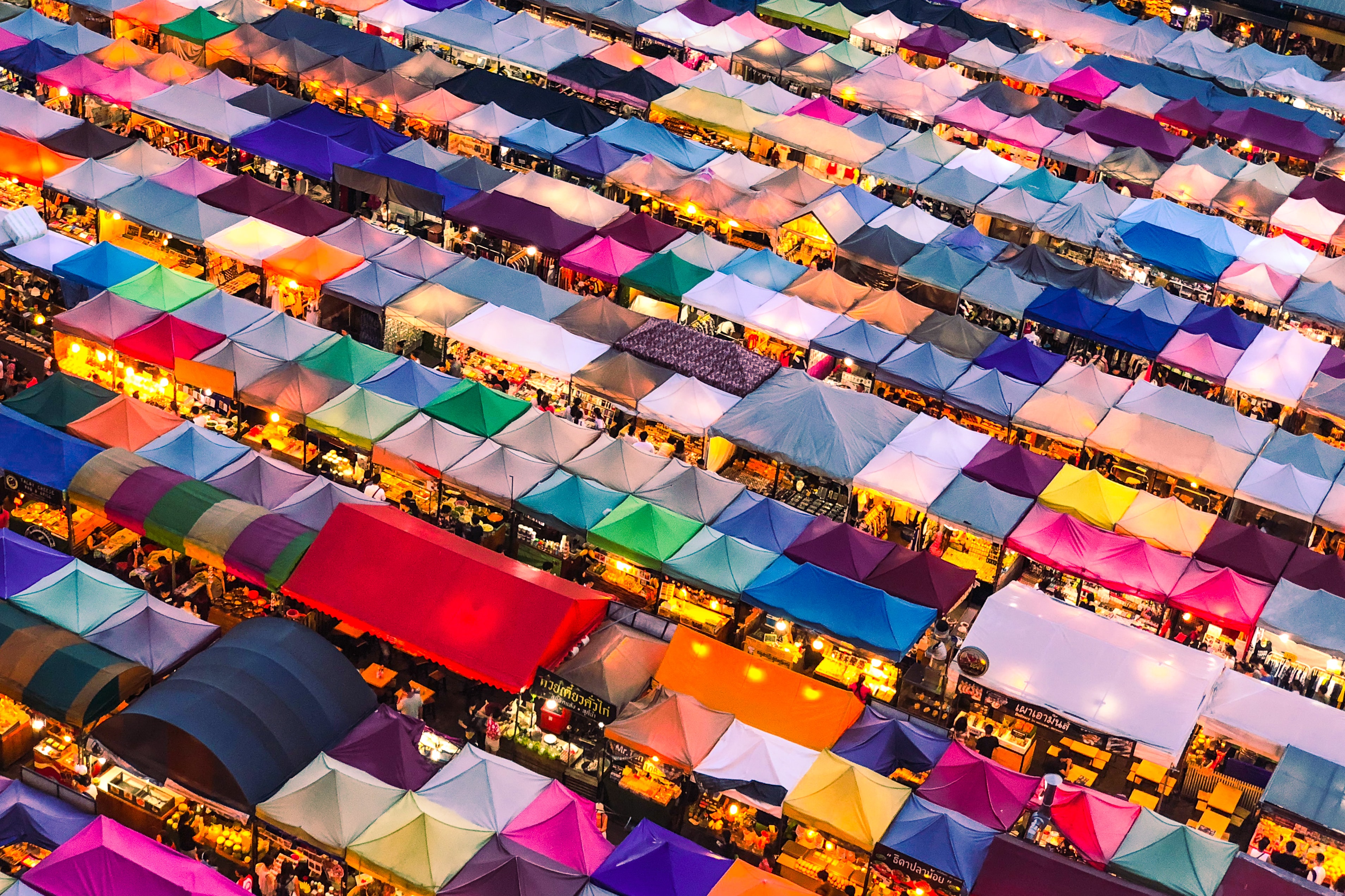 A drone view of rows and rows of marketplace stalls at dusk