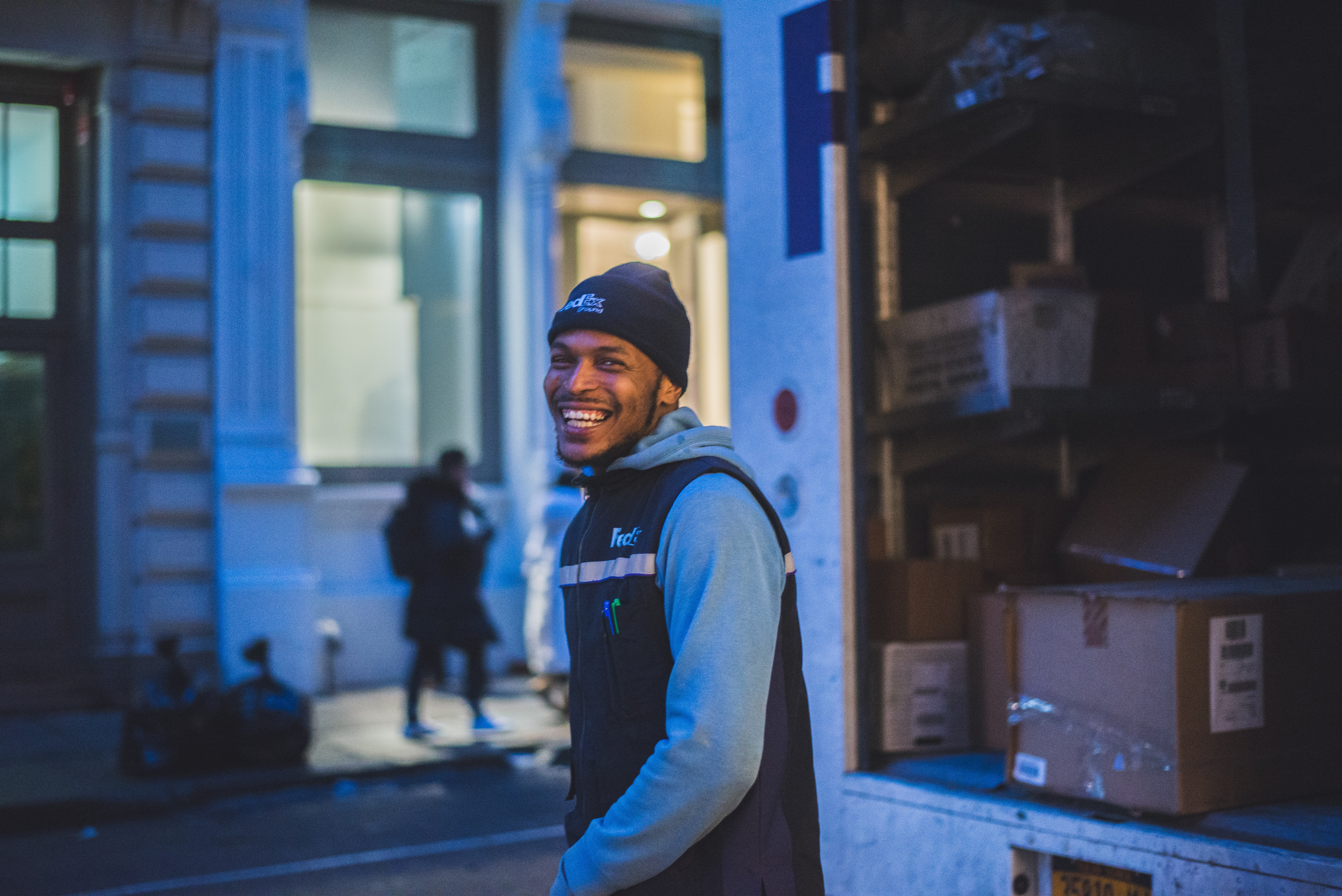 A delivery driver smiling by his truck.