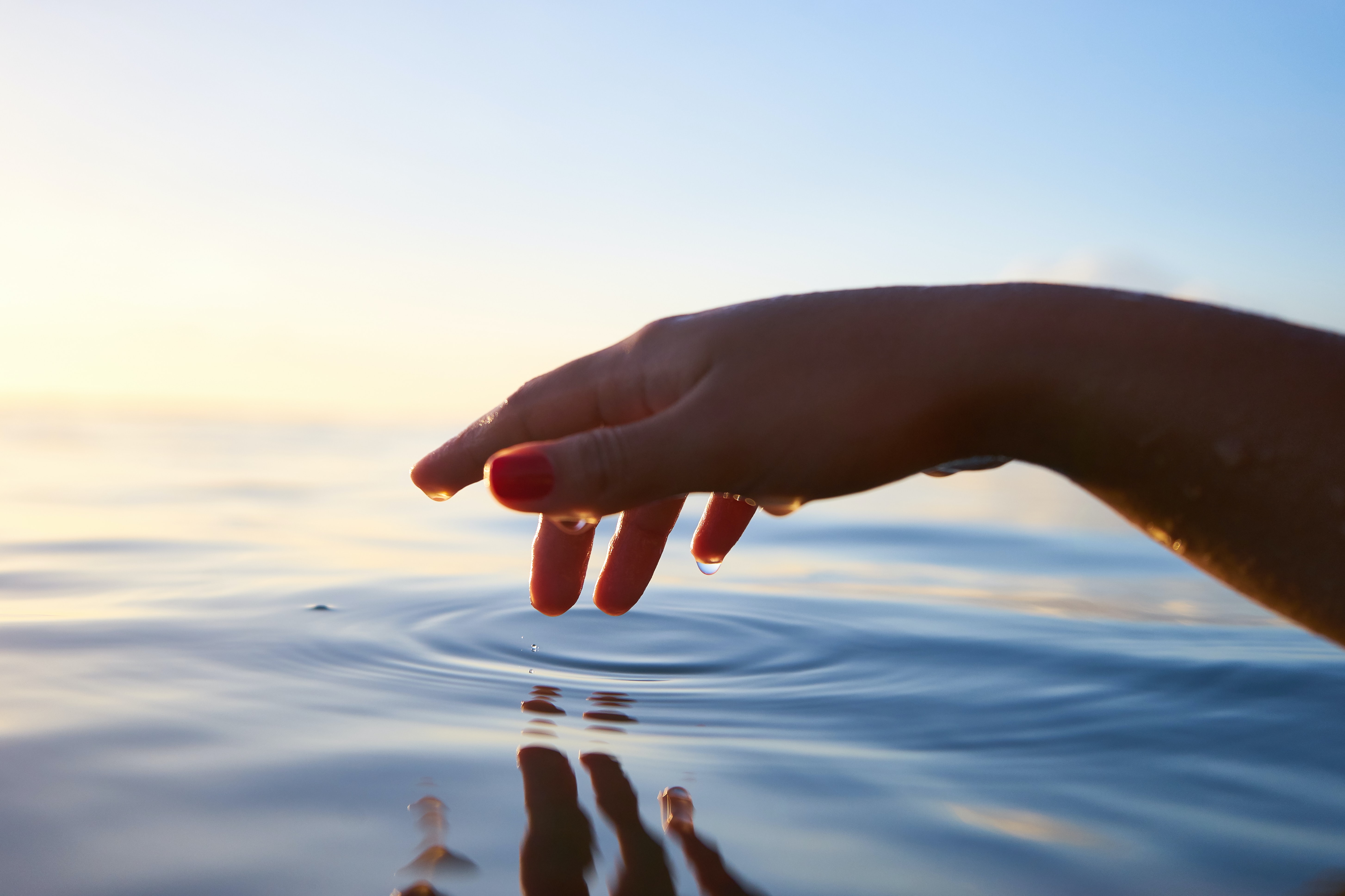 A hand touched the surface of the water.