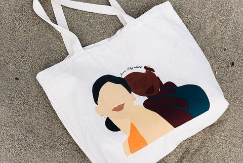 A fabric tote bag with a print of two women