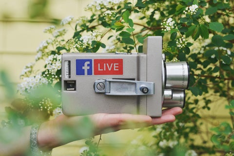 A retro film camera with a 'Facebook Live' sticker on the side