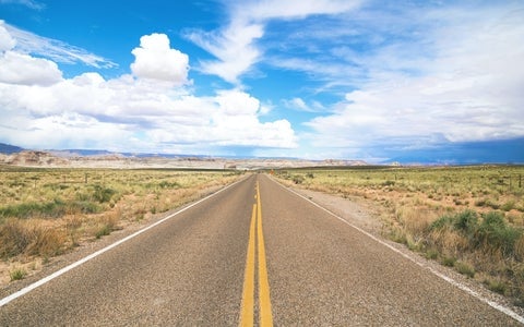 A long, flat, empty road cutting through the desert