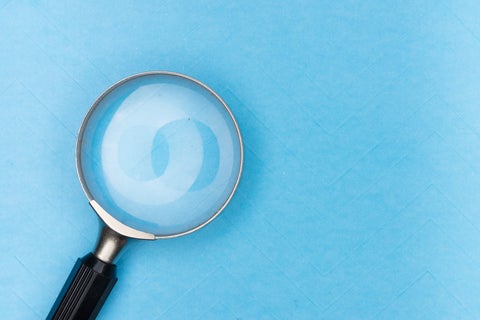 A magnifying glass against a plain blue background