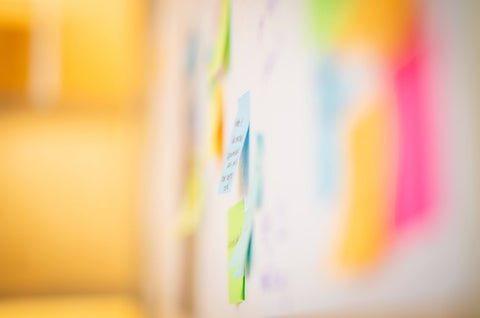 Out of focus shot of multi-colored Post-Its on a wall