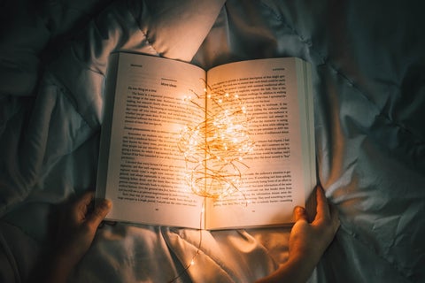 A book laid open with fairy-lights at the spine
