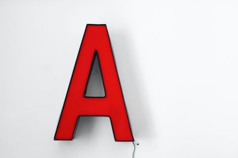 A red letter 'A' lamp against a white background