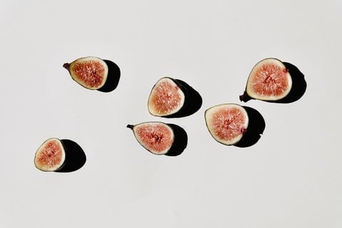 Cut up fruit lies on a white background