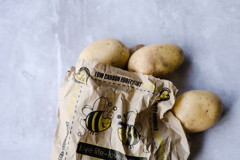 A bag of potatoes on a kitchen counter. The packaging reads: low carbon footprint