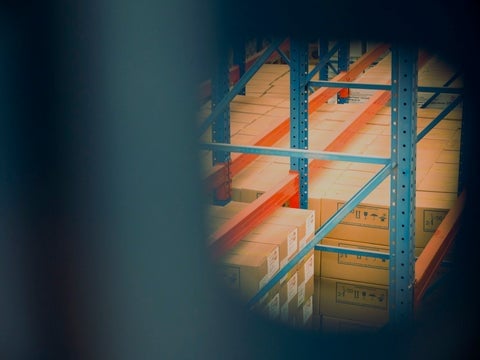 An image of a CPG distribution center with a stack of cardboard boxes in soft focus