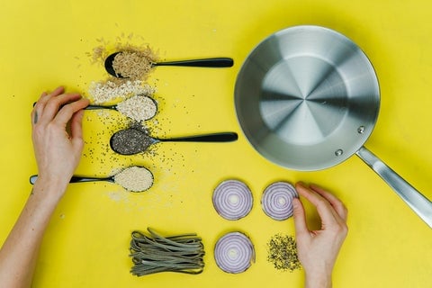 A woman lays out recipe ingredients on a bright yellow table