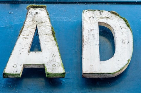 The letters 'AD' in big, white wooden letters on a blue wall
