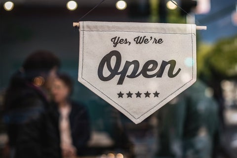 A store door sign that reads 'Yes, we're open' 