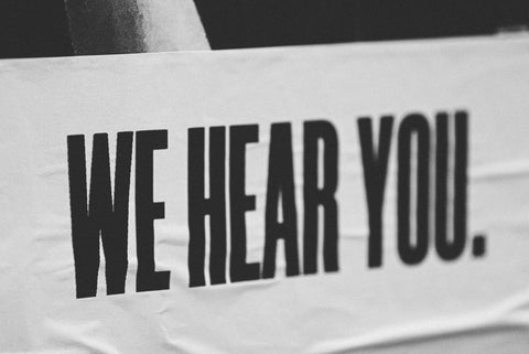 A poster that reads, in black bold uppercase: "We hear you"