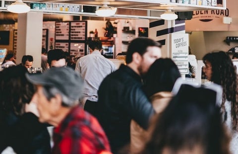 A busy food market floor, filled with people