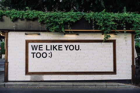 A street art poster that says "We like you too :)"