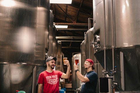 Two men raise a glass to their upstart craft beer