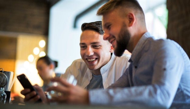 customers selecting their meal with smartphone in restaurant