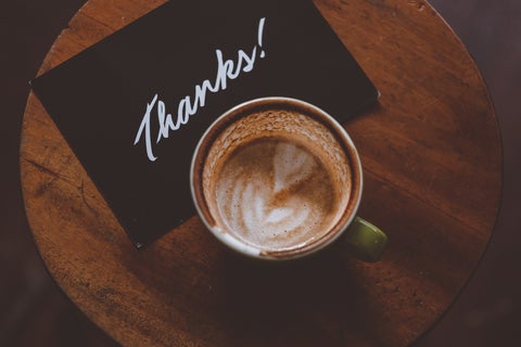 Overhead shot of an espresso drink below a napkin that says "Thanks!"