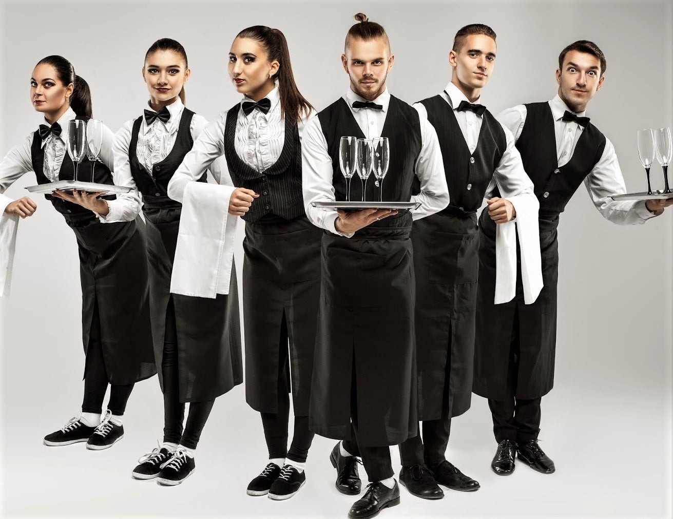 smart restaurant wait staff dressed in white shirts and black waistcoats
