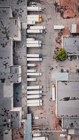Overhead shot of trucks parked outside of a warehouse.