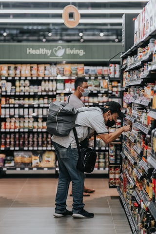 Two shoppers inspecting grocery store shelves.