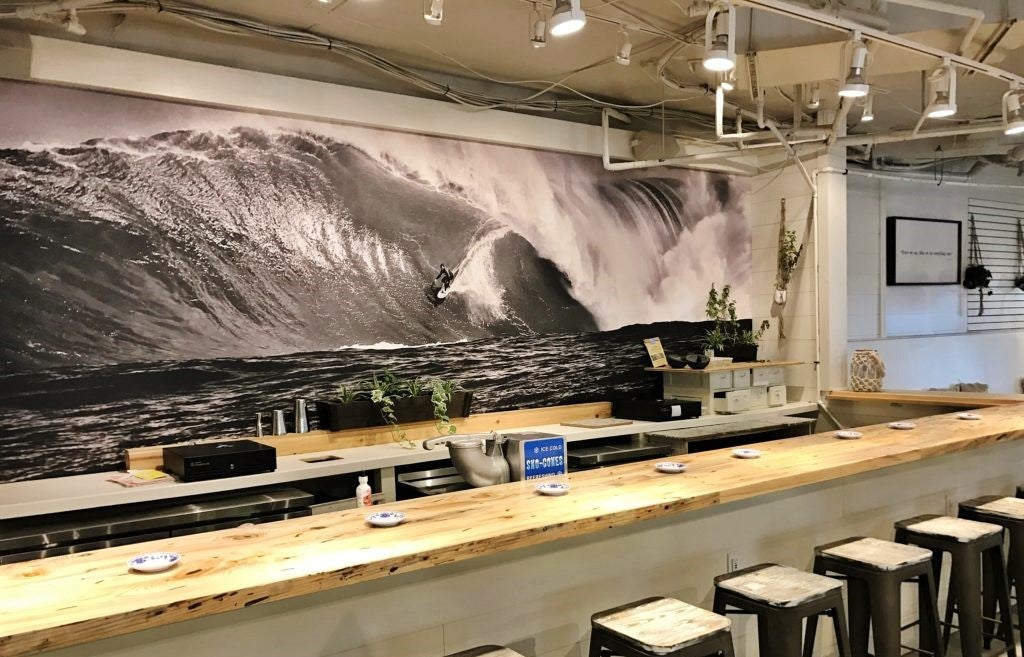 large restaurant mural of surfer positioned behind bar