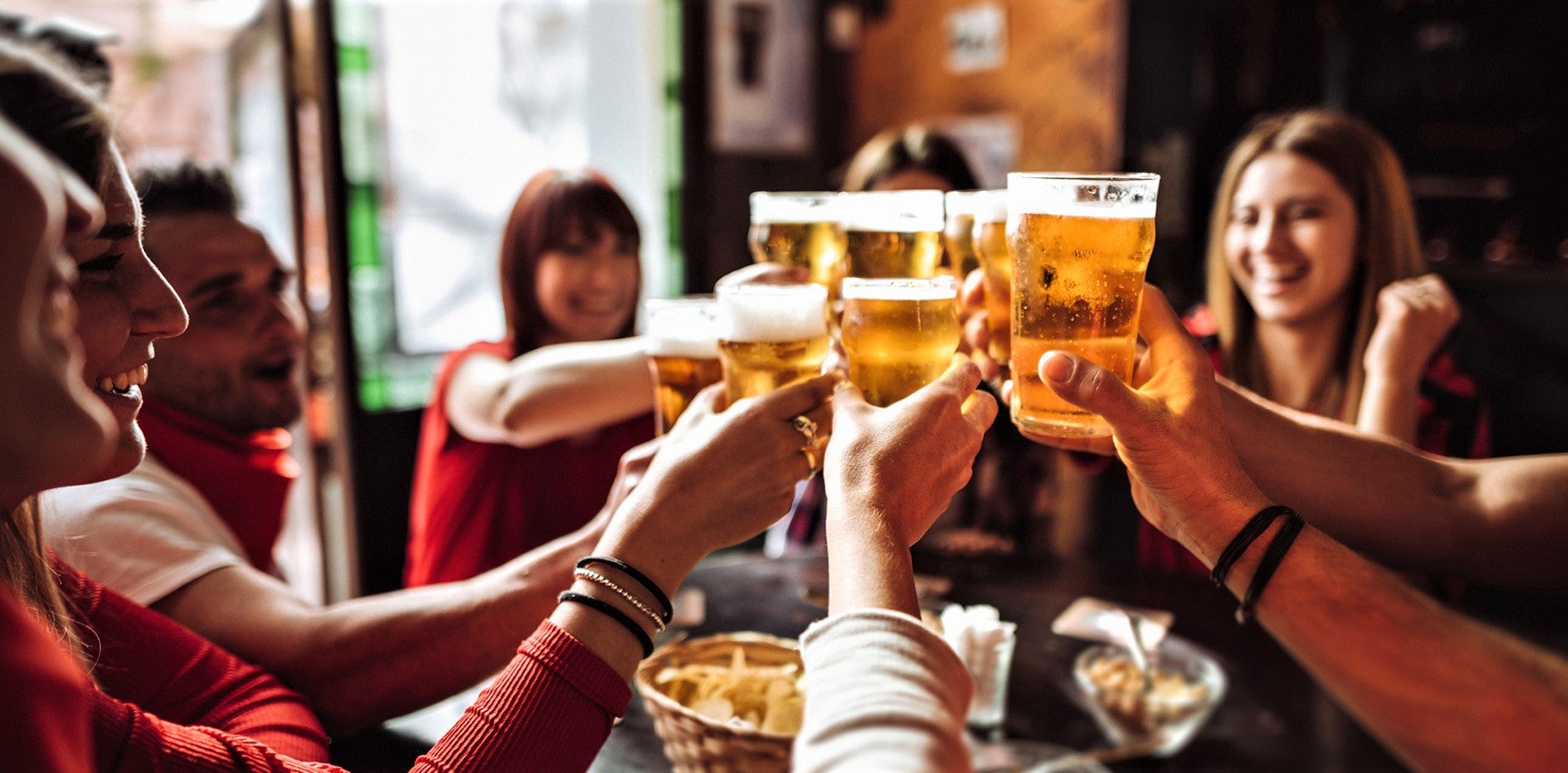group of friends raise a toast during restaurant happy hour