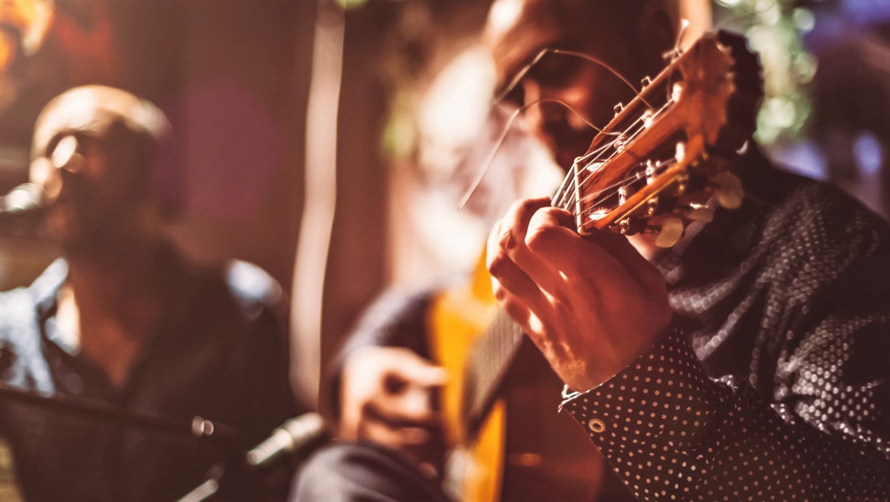 close up of guitar player's hand in live music performance