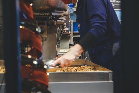 A packer scoops popcorn in a packing facility. 
