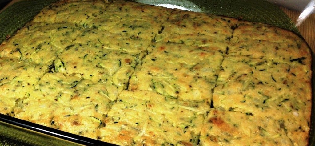 baking tray full of homemade zucchini squares cooking in the oven