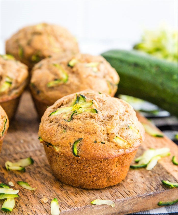 freshly baked zucchini muffins laid out on wooden chopping board